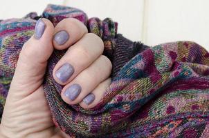 Hand of an adult woman with painted nails, manicure, nail polish photo