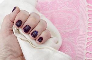 mano de una mujer adulta con uñas pintadas, manicura, esmalte de uñas