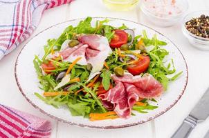 Fresh homemade salad with arugula, jamon, rucola, tomatoes, parmesan. photo