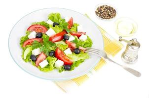 estilo de vida saludable. Ensalada de dieta vegetal con aceitunas y queso de cabra sobre fondo blanco. foto