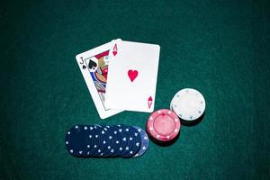 jack spade heart ace card with casino chips stack green poker table