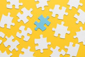 blue puzzle with white jigsaw piece yellow background photo