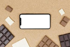 Vista superior de barras de chocolate con smartphone foto