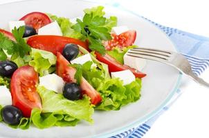 Healthy lifestyle. Vegetable diet salad with olives and goat cheese on white background. photo