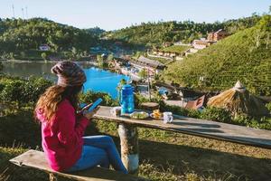 The Girl travel on the mountain. She is watching the scenery beautiful of Ban Rak Thai village, Drink coffee and eat food, snack in the morning.