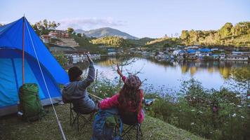 Asian couple Mountain camps in rural villages, close to the lake, travel ideas, camping, relaxing holidays.in Thailand photo