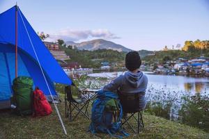 Asian man travel nature. Travel relax, Camping in a rural village on the mountain, near the lake. photo