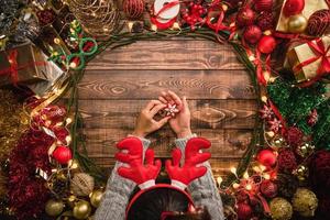 chica poniendo composición plana de Navidad en el fondo de madera con espacio de copia de su texto. Feliz navidad y próspero año nuevo. foto