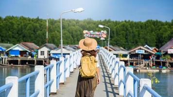 chica viajera con mochila caminando sobre el puente sobre el lago turismo en aldeas rurales ban bang phat - phangnga. naturaleza de viaje de mujer asiática. viajar relajarse. viajar a tailandia. verano, vacaciones, turista.