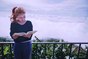 mujeres relajarse leer libro de la mañana buen tiempo cielo niebla. en las montañas, el ambiente de la mañana.