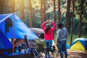 mujer asiática viajar naturaleza acampar en la montaña ver el lago en la niebla al amanecer de la mañana en pang ung, provincia de mae hong son, tailandia. foto