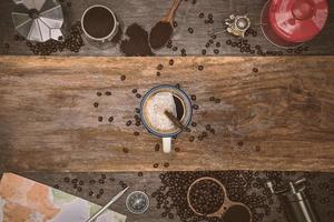 Brown coffee beans And a cup of hot coffee placed on a wooden table. Concept travel with map. Time to relax with a cup drink of good coffee. Top view copy space for your text. photo