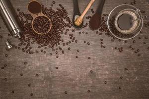 Brown coffee beans And a cup of hot coffee placed on a wooden table with honey. Wooden background with espresso and beans. Top view with copy space for your text. photo