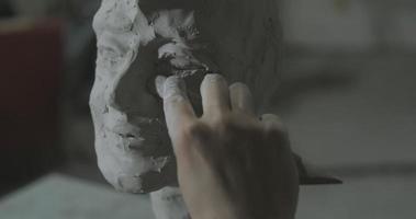 Sculptor work with clay portrait of female in dark studio UHD4K photo