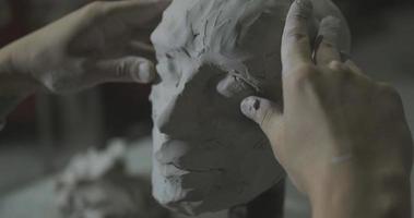 Sculptor work with clay portrait of female in dark studio UHD4K