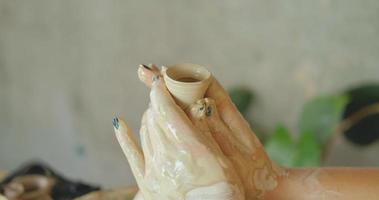 Close up of womans hand work with clay in pottery studio