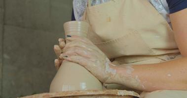 Close up of womans hand work with clay in pottery studio photo