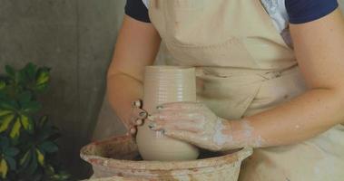 Close up of womans hand work with clay in pottery studio photo