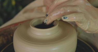 Close up of womans hand work with clay in pottery studio photo