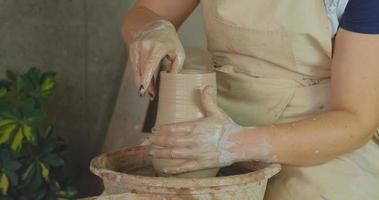 Close up of womans hand work with clay in pottery studio photo