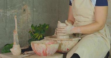 Close up of womans hand work with clay in pottery studio photo