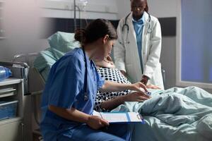 Medical assistant checking oximeter attached to senior man photo