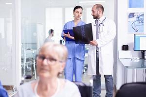 Doctor explicando el diagnóstico a la enfermera en la sala de espera. foto