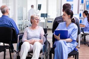 Nurse talking with disabled senior woman photo
