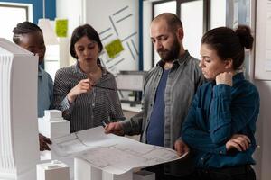 Team of multi ethnic architects designing blueprint plan photo