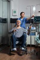 Medical practitioner preparing senior sick hospitalized man photo