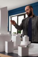 Architect man looking at design in professional office photo