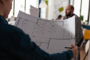 Architects looking at plans of blueprints for design photo