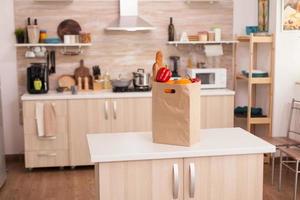 Paper bag filled with groceries on kitchen table top