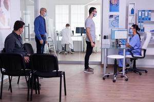 Young man checking appointment respecting social distancing in hospital photo