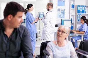 Doctor explaining diagnosis to nurse on tablet pc photo