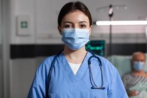 Médico especialista en atención médica con máscara quirúrgica en la habitación del hospital foto