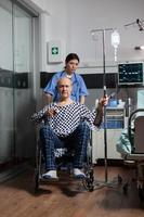 Medical practitioner preparing senior sick hospitalized man photo