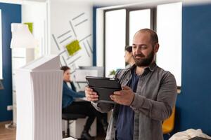 Work manager man looking on tablet at architecture office photo