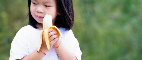 Banana in hands little child girl. Selective focus. photo