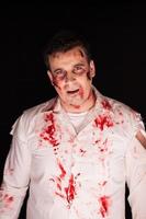 Scary zombie with blood on him after a murder photo