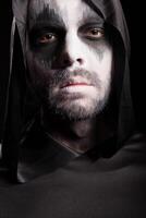 Close up portrait of grim reaper isolated over black background photo