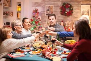 Cheerful big family clinking a glass of wine photo