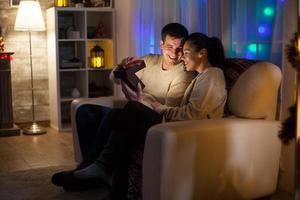 Couple in love on christmas day sitting on couch