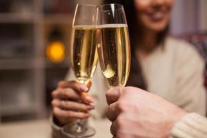 Close up of champagne glasses holded by cheerful couple photo