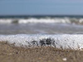 wave on the seashore with sand photo