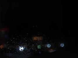 Raindrops on glass and bright lights photo