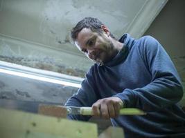 woodworker sawing a wooden beam photo