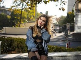 girl with flowing hair sits on a bench photo