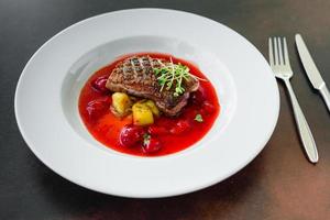 Steak from fillet of a duck with caramelized strawberry photo