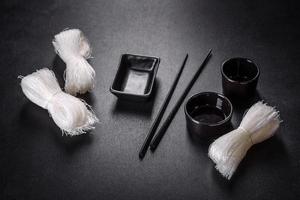 Dry uncooked rice noodles or rice vermicelli on a black cloth background photo